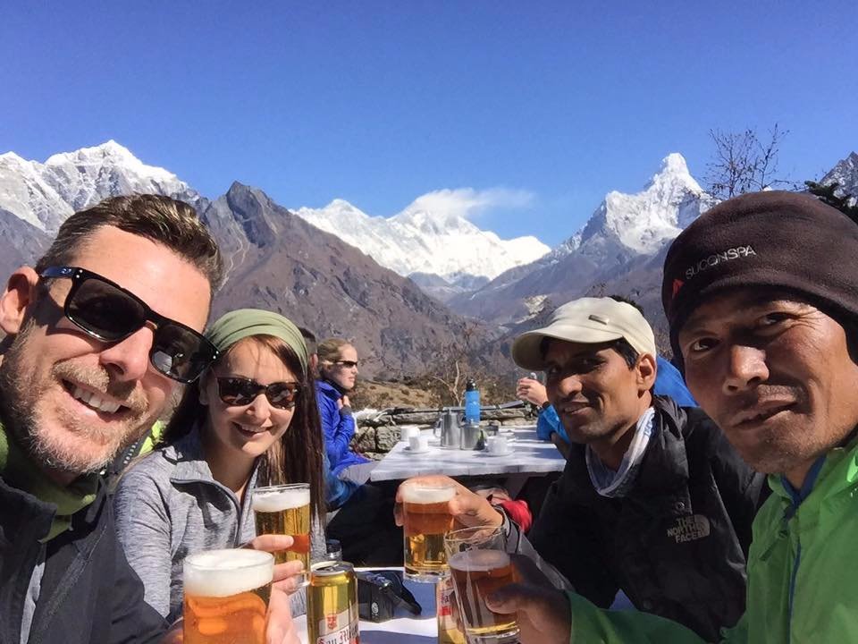 "Enjoying a beer with our guides and Mt Everest"